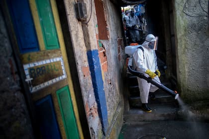 Un voluntario desinfecta un callejón en la favela de Santa Marta en Río de Janeiro, Brasil, durante la pandemia de coronavirus