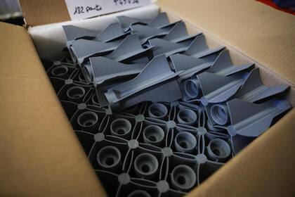 Un voluntario muestra las partes de plástico que imprime en Francia y que le envía a los militares ucranianos por correo; la red Druk Army ya fabricó más de 150 toneladas de piezas impresas en forma casera (Photo by Geoffroy VAN DER HASSELT / AFP)�