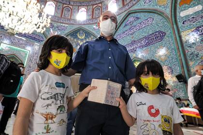 Un votantes y sus hijos en Teherán