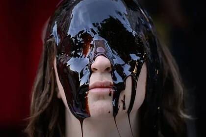 Una activista del grupo de acción directa Fossil Free London se situó frente a las oficinas de la empresa energética Shell en mayo y se cubrió los ojos con una sustancia