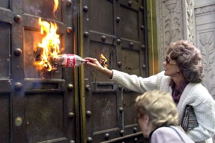 La crisis 2001. Una ahorrista intenta prender fuego a la puerta del Banco Boston en el centro porteño