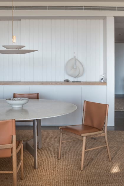 Una alfombra de fibras naturales contiene generosamente este comedor creado por la diseñadora Valeria Lamas