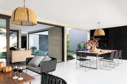 Una ambientación elegante, liviana y práctica: sillones, mesas y sillas de exterior (Mausy Design). Lámparas colgantes (San Isidro Luz)