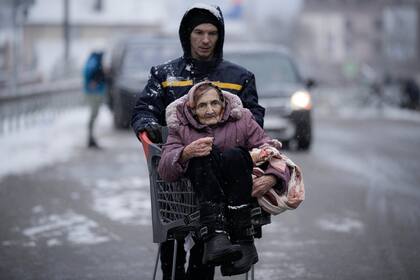 Una anciana es transportada en un carrito de compras después de ser evacuada de Irpin, en las afueras de Kiev, Ucrania