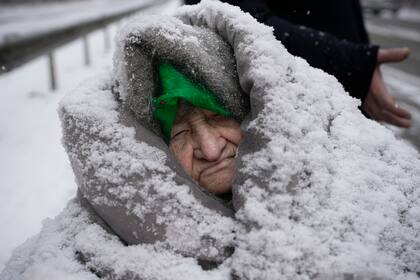 Una anciana sentada en una silla de ruedas, envuelta en mantas después de ser evacuada de Irpin, en las afueras de Kiev, Ucrania