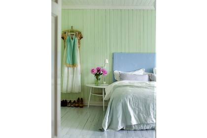 Una antigua pared machimbrada recobra vida con el verde menta en este dormitorio simple y despojado