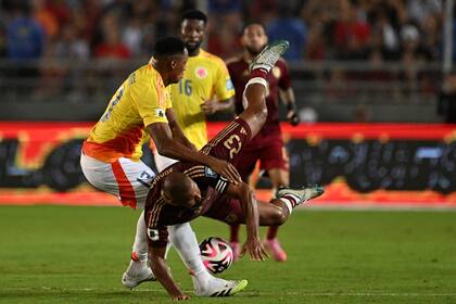 Una aparatosa caída de Salomón Rondón tras el cruce con Yerry Mina (Photo by Juan BARRETO / AFP)