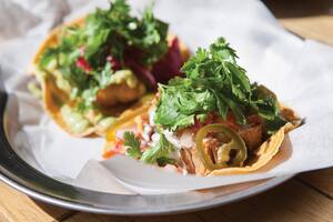 Una badeja con dos nachos listos para servir