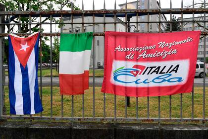 Una bandera cubana, una bandera italiana y una bandera de la asociación italo-cubana se ven fuera del hospital Maggiore en Crema, sureste de Milán