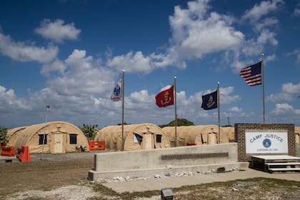 Una bandera nacional estadounidense y otras ondean frente a carpas militares el 18 de abril de 2019 en la base naval de Guantánamo, Cuba (AP Foto/Alex Brandon, Archivo)