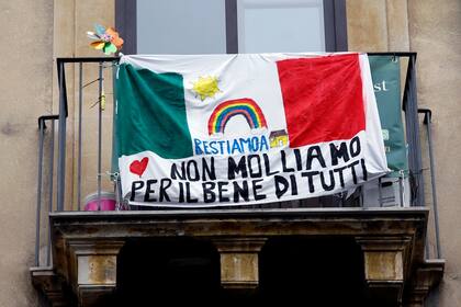 Una bandera que dice "Nos quedamos en casa, no nos rendimos por el bien de todos"