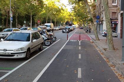 Una bicisenda de Barcelona: ancha, nivelada y con una franja de seguridad respecto de los automóviles y motos estacionados