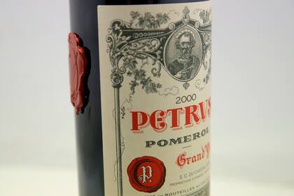 Una botella de vino Petrus que pasó un año en la Estación Espacial Internacional como parte de un experimento científico y que será subastada, en París, el 3 de mayo de 2021. (AP Foto/Christophe Ena)
