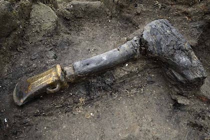 Una cabeza de hacha de metal con mango de madera se encontraba entre los muchos artefactos bien conservados