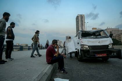 Una camioneta dañada por las explosiones es revisada por su propietario