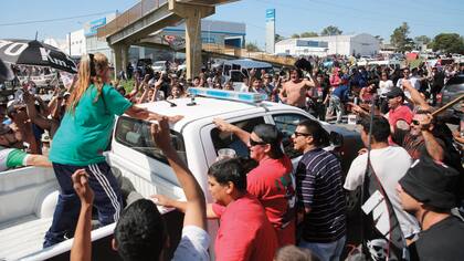 Una camioneta de la policía queda cercada por la algarabía de los fanáticos