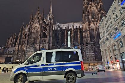 Una camioneta policial permanece estacionada el sábado 23 de diciembre de 2023 frente a la catedral de Colonia, Alemania. (Sascha Thelen/dpa vía AP)