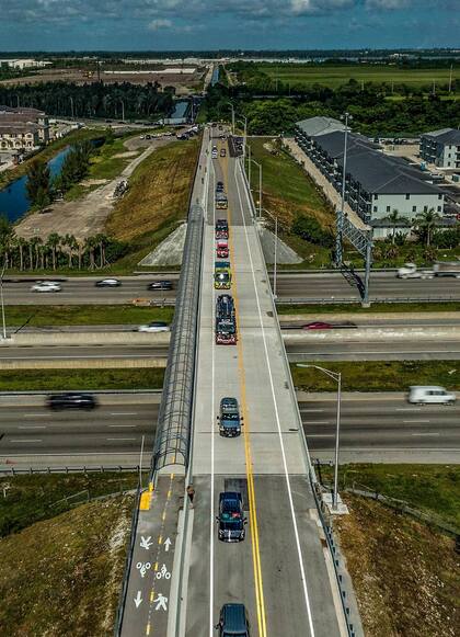 Una caravana que incluye vehículos de emergencia y fuerzas del orden cruza el puente de NW 170th St. que cruza la interestatal 75 y conecta Hialeah y Miami Lakes (Crédito: Pedro Portal)