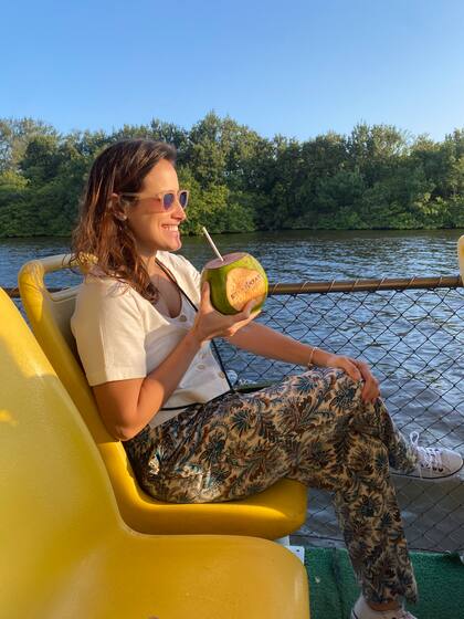 Una carioca toma agua de coco durante un paseo por la laguna Marapendi.