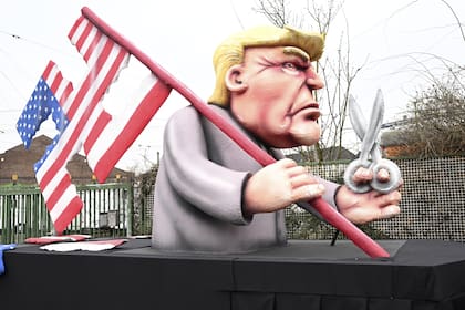 Una carroza con una figura del candidato presidencial estadounidense Donald Trump sosteniendo una bandera estadounidense y tijeras en la mano es conducida durante el desfile del Lunes de las Rosas, en Düsseldorf, Alemania, el lunes 12 de febrero de 2024.