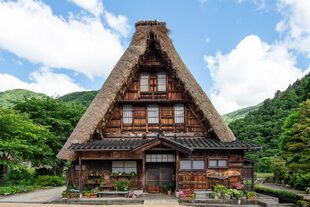 Una casa con techo de paja de 170 años de antigüedad en el estilo tradicional Gassho-zukuri alberga un dormitorio amplio y una sala de estar relajada.