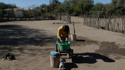 Una chica discapacitada lava la ropa en un fuentón; Lucía, su madre, cobra una pensión graciable