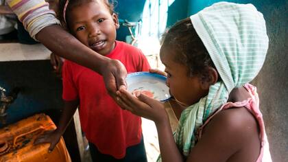 Una chica toma agua en Madagascar
