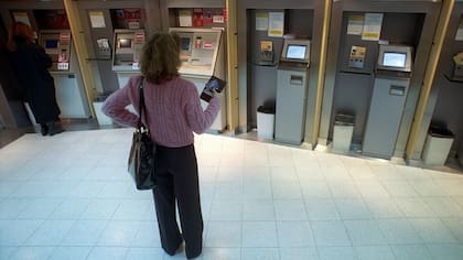 Una clienta espera en los cajeros de su banco.