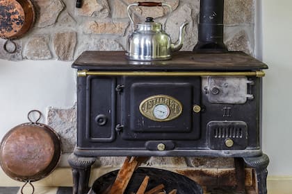 Una cocina económica a leña refuerza el estilo de campo de la casa.
