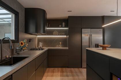 Una cocina “net”. La campana con líneas suaves dialoga con la barra central.