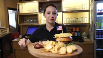 Una cocinera enseña un plato típico estadounidense en el restaurante Rondo en el centro de Sevnica, Eslovenia