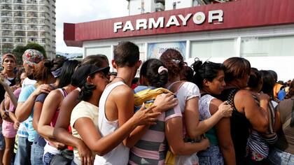 Una cola para comprar pañales en una farmacia de Caracas