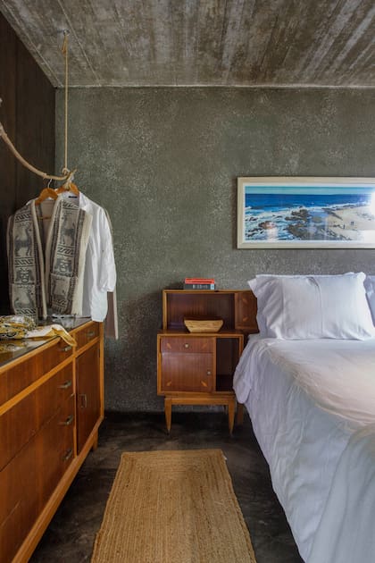 Una cómoda modernista hace juego con las mesas de luz (Castells) y una soga de yute oficia de perchero.