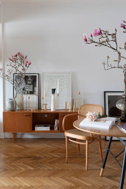 Una cómoda vintage sostiene los candelabros de bronce que Irina mandó a hacer en Argentina. Coronando la puesta, las flores de Magnolia.