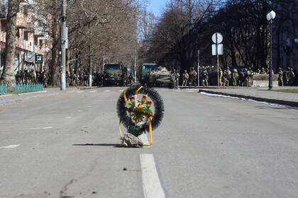 Una corona de flores en una calle mientras los soldados del Ejército ruso están cerca de sus camiones durante una manifestación contra la ocupación rusa en Kherson