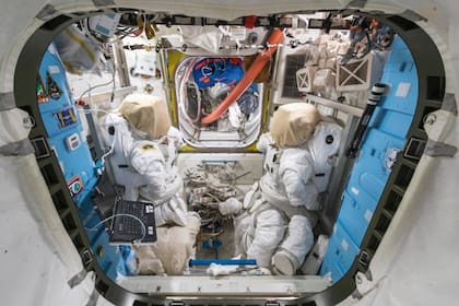 Una de las escotillas para salir al espacio exterior y dos trajes de astronautas