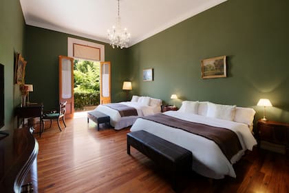 Una de las habitaciones con vista al jardín. Amplias y luminosas, tienen escritorios, muebles de época y salida a la galería.