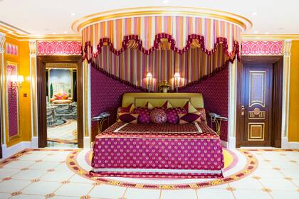 Una de las impresionantes suites de dos pisos, decorada en tonos magenta y dorado.