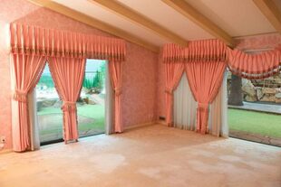 Una de las habitaciones tiene la alfombra, cortinas y empapelado rosa
