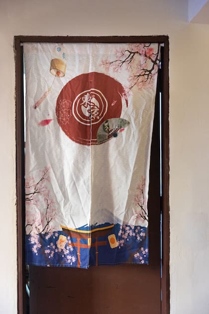 Una de las puertas del local con una cortina japonesa