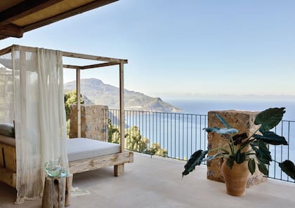 Una de las terrazas que acompañan las suites de planta alta. Vuelven los pisos de piedra Santanyí, interrumpido por las columnas de piedra anaranjada proveniente de la localidad mallorquina de Esporles