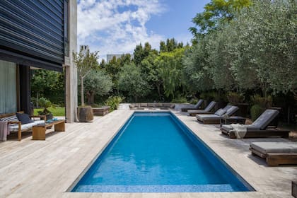 Una de las últimas incorporaciones fue el fogonero (al fondo), que embutieron en el piso de Travertino a la veta rústico (Centro del Mármol). Colchonetas y almohadones de Sunbrella.