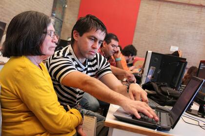 Una de los asistentes del FLISoL 2014 junto a uno de los voluntarios que realizó la instalación de software libre durante la jornada que se llevó a cabo en Rosario