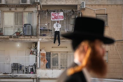 Una efigie del líder de Hamás, Yahya Sinwar, cuelga del balcón de un apartamento bajo el cartel "Indeseado", en Jerusalén el jueves 28 de marzo de 2024. (Foto AP/Ohad Zwigenberg)