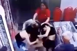 Una empleada de una cadena de supermercados intenta separar a dos clientas que intercambian golpes tras una discusión