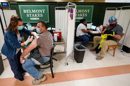 Una enfermera aplica la primera dosis de la vacuna de Pfizer contra el coronavirus a trabajadores de la industria metalúrgica, en un centro de vacunación en Belmont Park, el miércoles 14 de abril de 2021, en Elmont, Nueva York. (AP Foto/Mary Altaffer)