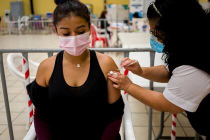Una enfermera aplica un refuerzo de AstraZeneca contra el COVID-19 en un centro de vacunación en Ciudad de Guatemala, el martes 1 de marzo de 2022. (AP Foto/Moises Castillo)