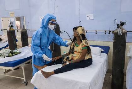 Una enfermera atiende a una paciente en un centro gratuito par enfermos de COVID-19 operado por una ONG a las afueras de Nueva Delhi, India