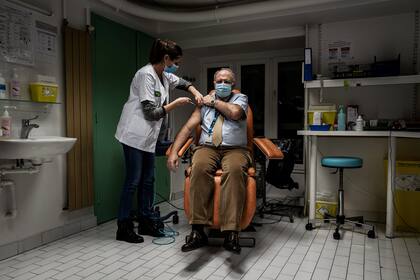 Una enfermera inyecta una dosis de la vacuna de Pfizer y BioNTech contra la Covid-19 a un miembro del personal médico del Hospital Croix Rousse, el 6 de enero de 2021, en Lyon, como parte de la campaña nacional de vacunación de Francia