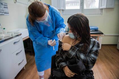 Una enfermera le aplica una inyección de la vacuna Pfizer contra COVID-19 a una joven en Montevideo. (AP Foto/Matilde Campodónico)